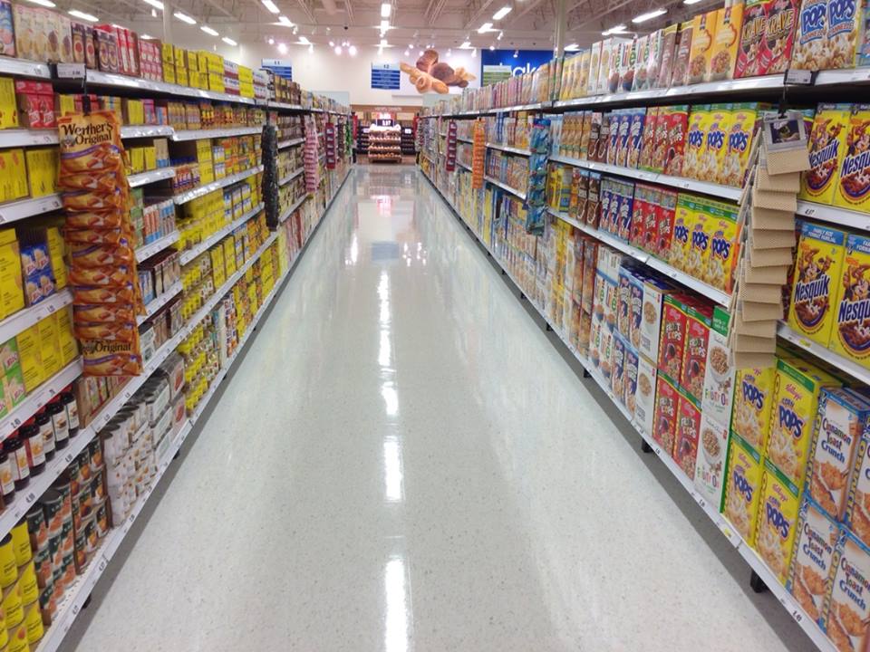 A shopper comparing products in a retail aisle.